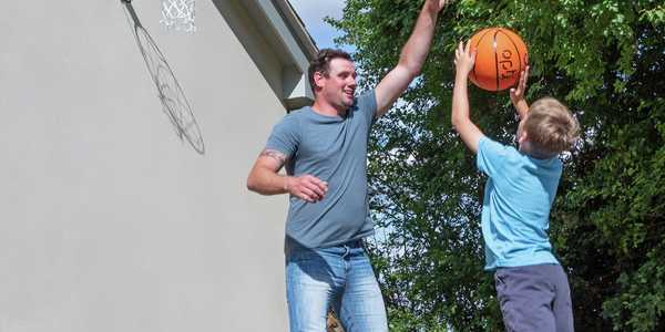 A father playing basketball with his son.